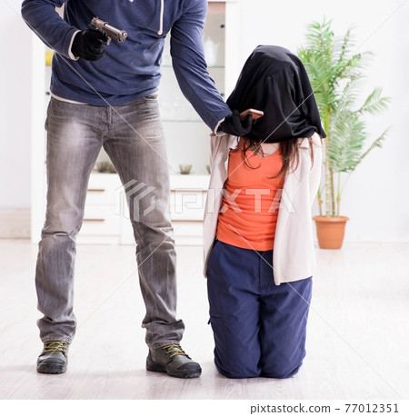 Armed man assaulting young woman at home 77012351