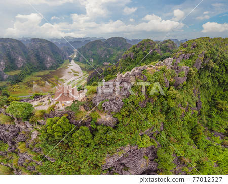 Amazing huge dragon statue at limestone mountain top near Hang Mua view point at foggy morning. Popular tourist attraction at Tam Coc, Ninh Binh. Vietnam travel landscapes and destinations. Vietnam Amazing huge dragon statue at limestone mountain top near Hang Mua view point at foggy morning. Popular tourist attraction at Tam Coc, Ninh Binh. Vietnam travel landscapes and destinations. Vietnam 77012527