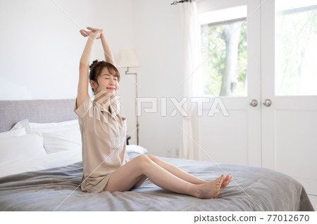 A cute woman who wakes up comfortably A cute woman who wakes up comfortably 77012670