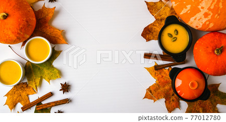 Autumn food. Frame of pumpkin puree soup, leaves. Top view. Autumn harvest, pumpkins, leaves on grey as abstract background. Thanksgiving day. Flat lay. Copy space Autumn food. Frame of pumpkin puree soup, leaves. Top view. Autumn harvest, pumpkins, leaves on grey as abstract background. Thanksgiving day. Flat lay. Copy space 77012780