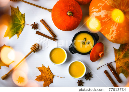 Autumn food. Pumpkin puree soup, leaves. Top view. Autumn harvest, pumpkins, leaves on grey as abstract background. Thanksgiving day. Flat lay. Autumn food. Pumpkin puree soup, leaves. Top view. Autumn harvest, pumpkins, leaves on grey as abstract background. Thanksgiving day. Flat lay. 77012784