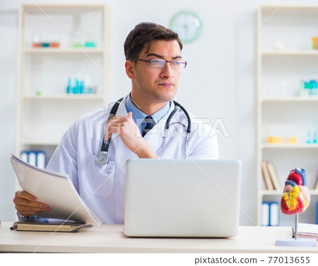 Doctor explaining the heart model Doctor explaining the heart model 77013655