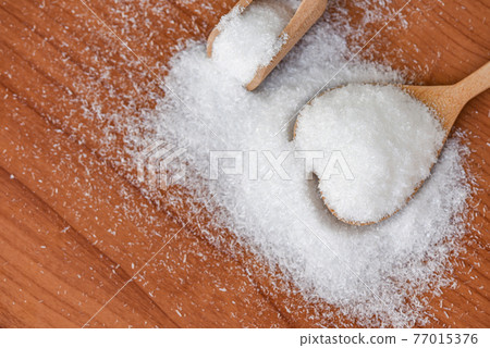 Monosodium glutamate on spoon and wooden table background, MSG for food seasoning 77015376