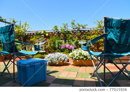 Outdoor chair & cooler box on the roof balcony, looking at the plants, relaxing time on holidays Outdoor chair & cooler box on the roof balcony, looking at the plants, relaxing time on holidays 77015936