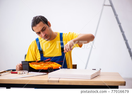 Young male carpenter working indoors 77016679