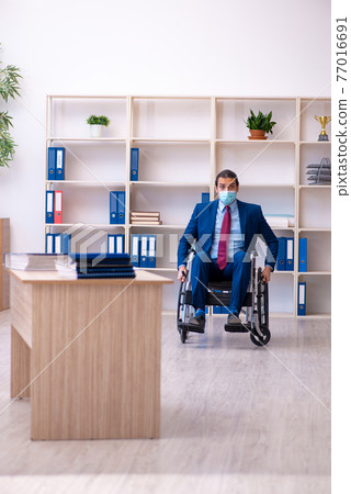 Young disabled employee during pandemic at workplace Young disabled employee during pandemic at workplace 77016691