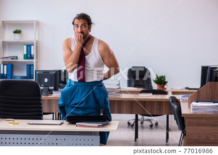 Young male employee coming to work straight from bed Young male employee coming to work straight from bed 77016986