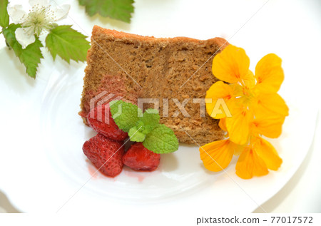 A piece of homemade coffee chiffon cake with edible flowers and strawberry jam A piece of homemade coffee chiffon cake with edible flowers and strawberry jam 77017572