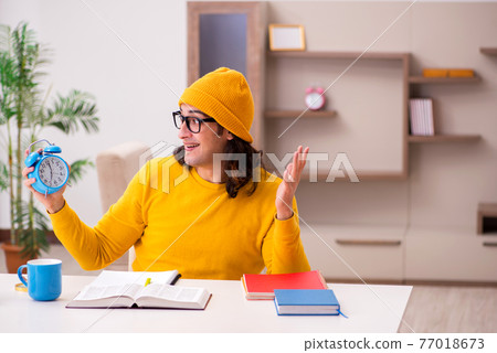 Young male student preparing for exams at home Young male student preparing for exams at home 77018673
