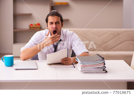 Young male employee working from home during pandemic Young male employee working from home during pandemic 77018675