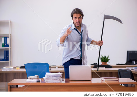 Young male furious employee holding axe in the office 77019490