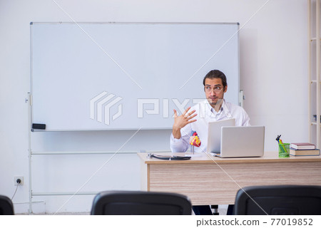 Young male doctor giving seminar in the classroom 77019852
