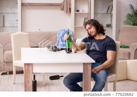 Young unemployed man drinking alcohol at home Young unemployed man drinking alcohol at home 77020662