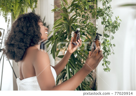Young cute womna choosing beauty products and feeling good 77020914