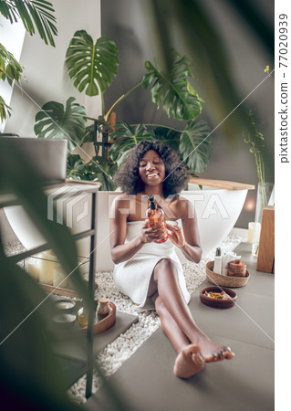 Pretty african american woman with natural beauty products Pretty african american woman with natural beauty products 77020939