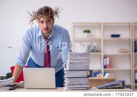 Young male employee wearing prickly wreath on head Young male employee wearing prickly wreath on head 77021837