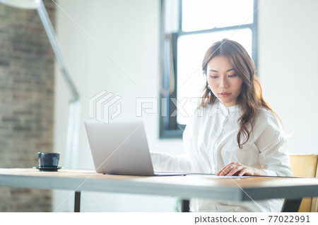 Young woman working remotely 77022991