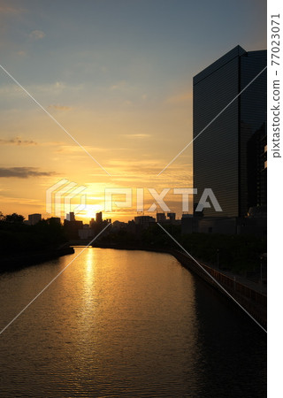 Sunset and twilight scenery reflected on the river surface Sunset and twilight scenery reflected on the river surface 77023071