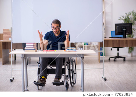 Young male handicapped student in the classroom 77023934