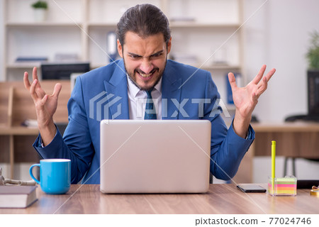 Young male employee working in the office Young male employee working in the office 77024746