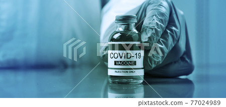 man shows a covid-19 vaccine, web banner 77024989