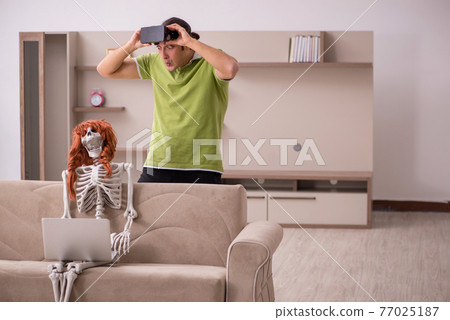 Young man with female skeleton in virtual reality concept Young man with female skeleton in virtual reality concept 77025187