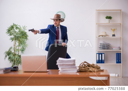 Young cowboy businessman working at workplace Young cowboy businessman working at workplace 77025388