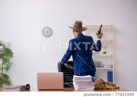 Young cowboy businessman working at workplace Young cowboy businessman working at workplace 77025389