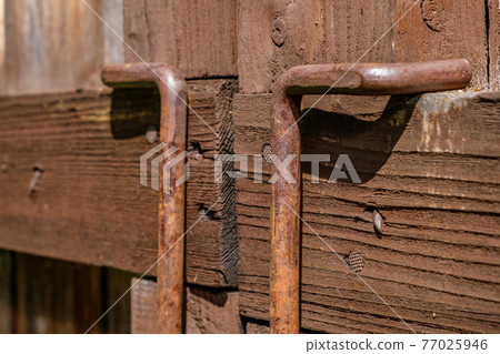 Metal latch on wooden gate closeup 77025946