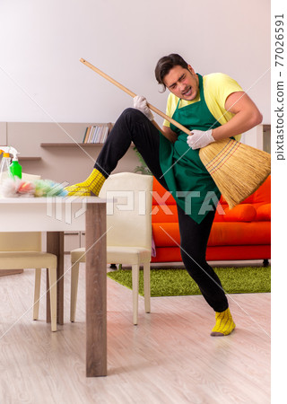 Young male contractor cleaning the house indoors Young male contractor cleaning the house indoors 77026591
