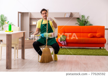 Young male contractor cleaning the house indoors Young male contractor cleaning the house indoors 77026592