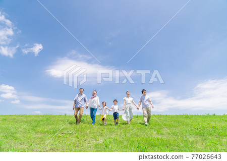 A three-generation family taking a walk under the blue sky 77026643