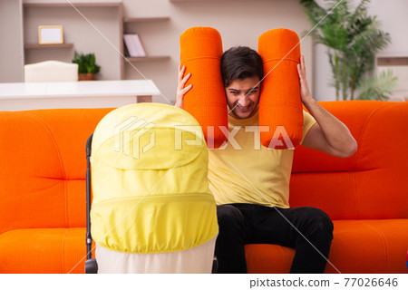 Young man looking after new born at home 77026646