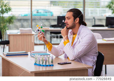 Young male chemist in drug synthesis concept 77026649