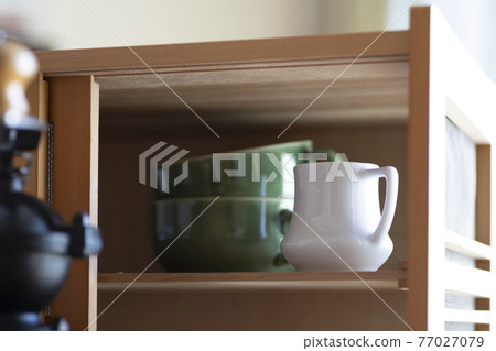 A coffee mill, a retro cupboard with milk pickers A coffee mill, a retro cupboard with milk pickers 77027079