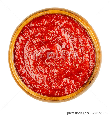 Homemade tomato ketchup in a wooden bowl. Red sweet and tangy table condiment, made from tomato paste, sugar, vinegar and seasonings, served to fried or greasy dishes. Close-up from above, food photo. Homemade tomato ketchup in a wooden bowl. Red sweet and tangy table condiment, made from tomato paste, sugar, vinegar and seasonings, served to fried or greasy dishes. Close-up from above, food photo. 77027369