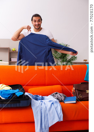 Young man student preparing for trip at home 77028170