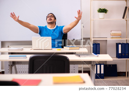 Young male student in the classroom Young male student in the classroom 77028234