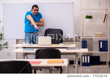 Young male student in the classroom Young male student in the classroom 77028238