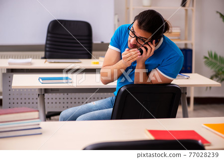 Young male student in the classroom 77028239