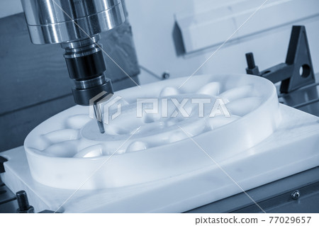 The CNC milling machine cutting the engineering plastic material . The CNC milling machine cutting the engineering plastic material . 77029657