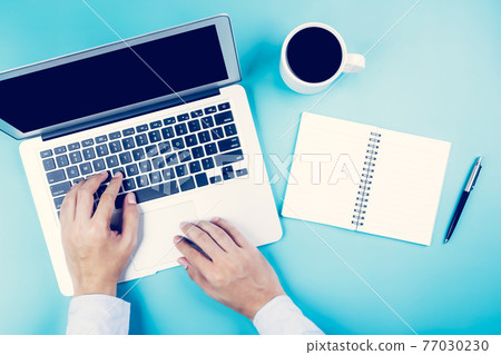 Hand of businessman working on laptop computer with notebook and cup of coffee. 77030230