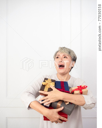 Senior asian woman holding mount of gift boxes, enjoying many best presents. 77030558