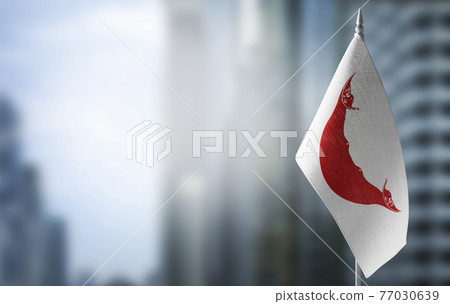 A small flag of Easter Island on the background of a blurred background 77030639