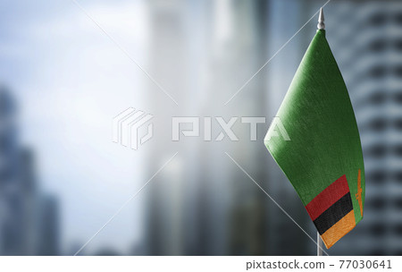 A small flag of Zambia on the background of a blurred background A small flag of Zambia on the background of a blurred background 77030641