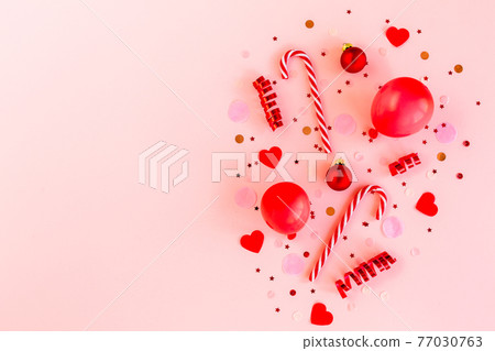Red box with confetti, balloons, streamers and decoration on a pink background. Colorful celebration, birthday background. Flat lay, top view Red box with confetti, balloons, streamers and decoration on a pink background. Colorful celebration, birthday background. Flat lay, top view 77030763