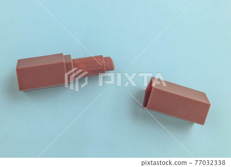 Beautiful fashionable beauty cosmetic glamorous red lipstick for applying makeup on the lips on a blue gentle background 77032338