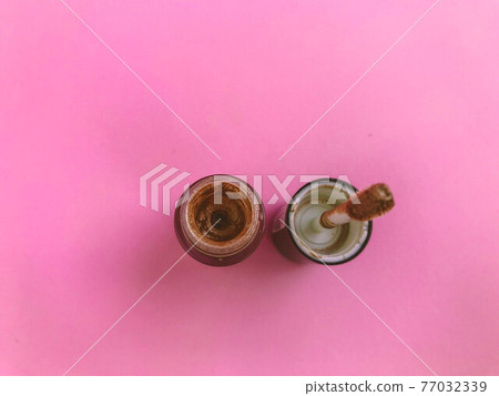 Lipstick and applicator wand on pastel pink backgrpund. Liquid lip stick open tube. Makeup cosmetic product. Top view, flat lay, copy space 77032339