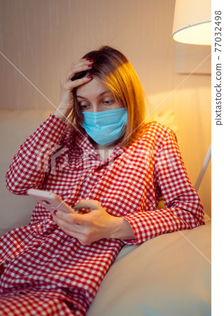 Young european woman wearing surgical face mask stay at home dur 77032498