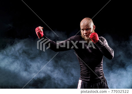 Sportsman boxer fighting on black background with smoke. Boxing Sportsman boxer fighting on black background with smoke. Boxing 77032522